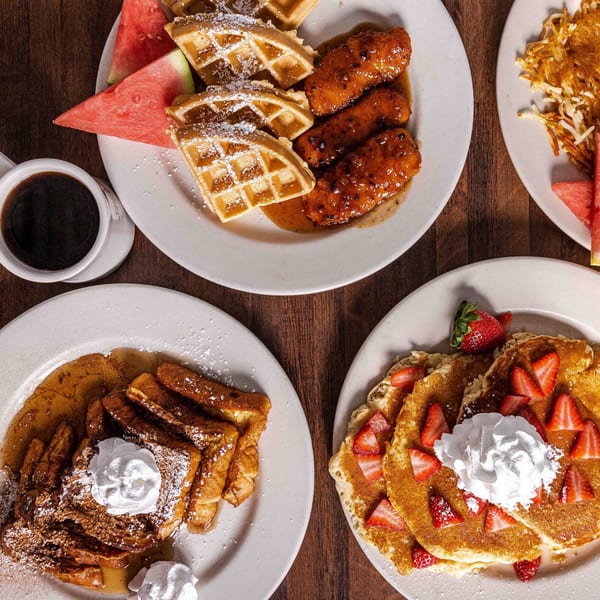 Overhead view of Foodys Tampa breakfast plates: chicken and waffles, French toast, and strawberry pancakes.